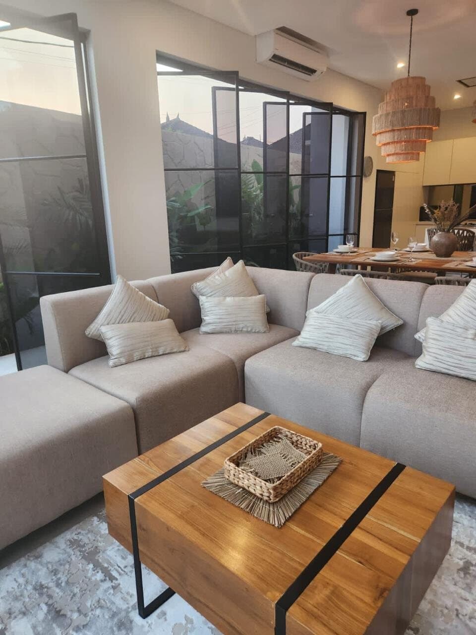Corner sofa and oak coffee table, steel-framed glazing to the garden